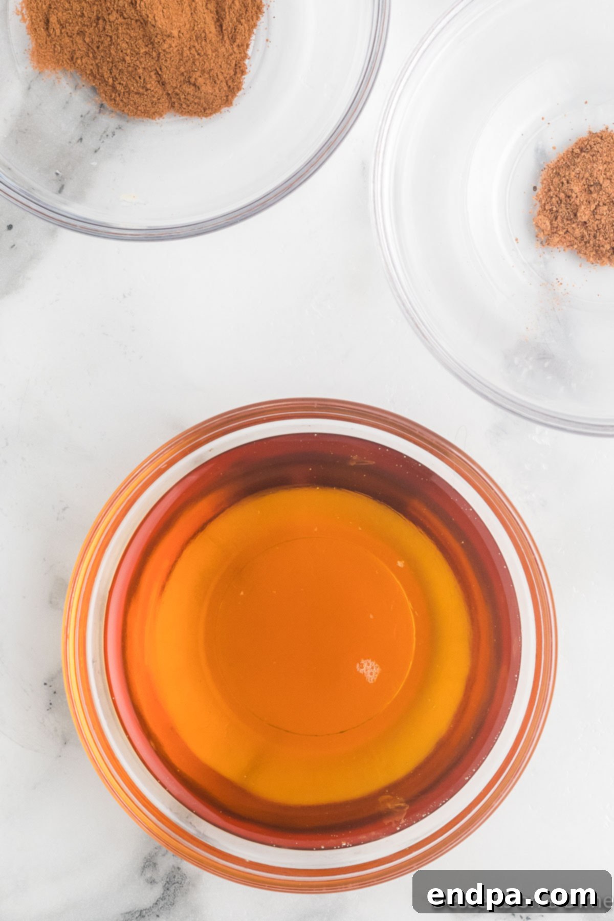 A small bowl containing maple syrup, cinnamon, and nutmeg mixed together.