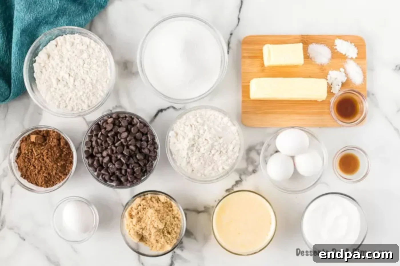 Ingredients for brookie recipe laid out: flour, butter, sugar, eggs, cocoa powder, chocolate chips.
