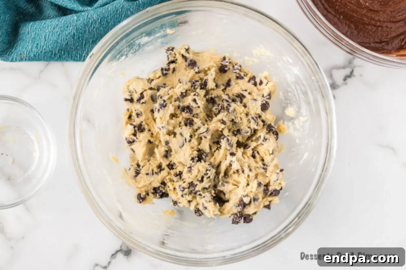 Mixing bowl with chocolate chip cookie dough, showing its rich texture.