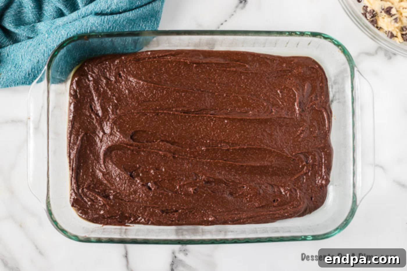 Brownie batter evenly spread in a 9x13 inch baking pan.