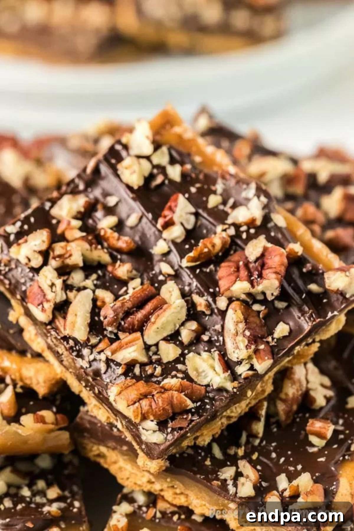 Graham Cracker Toffee stacked in squares, showcasing its crispy layers of chocolate, toffee, and graham cracker.