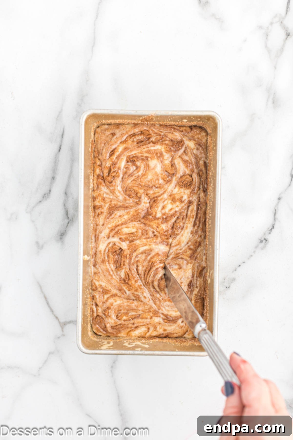 Knife swirling the cinnamon into the batter. 
