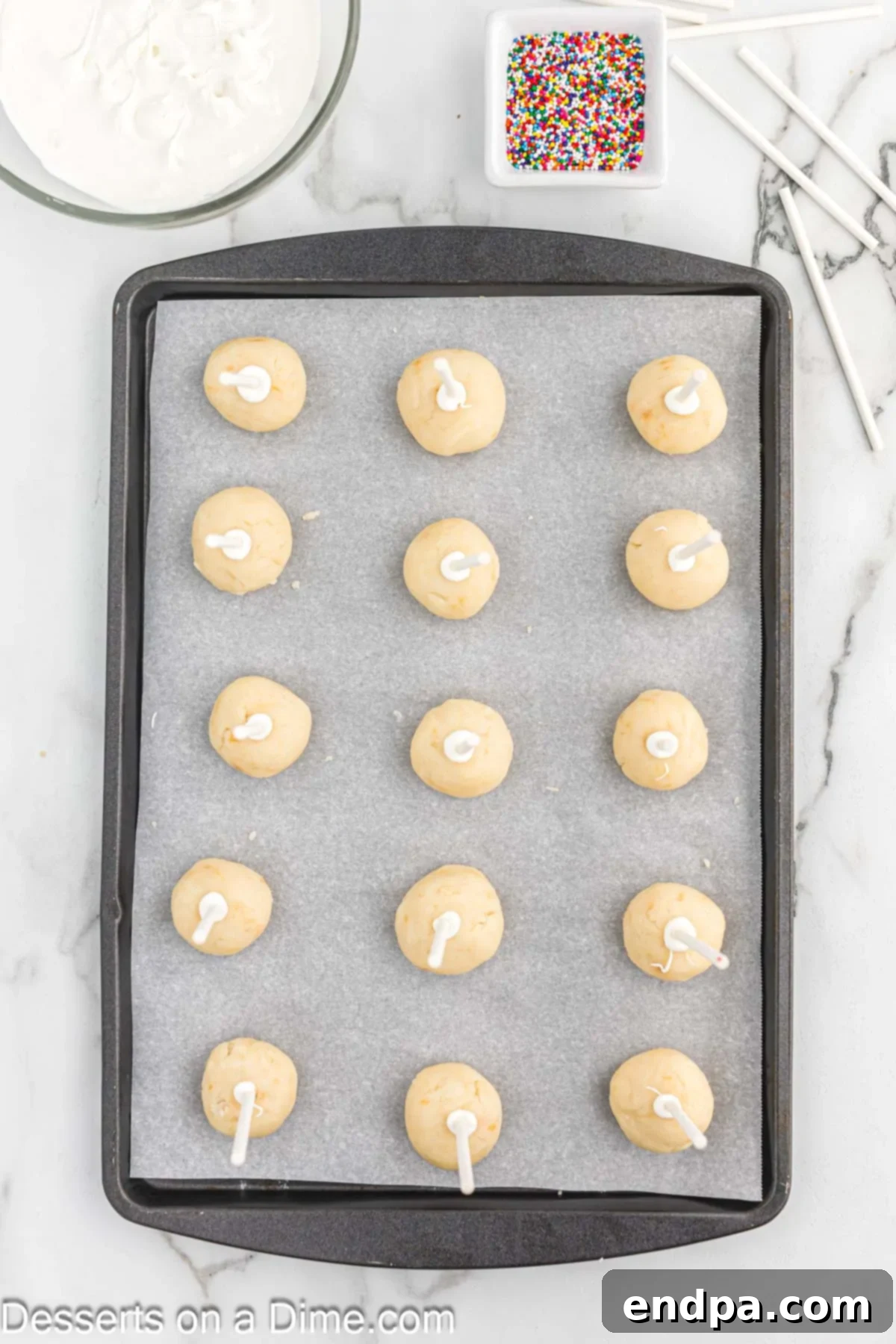 Whip Up Perfect Cake Pops 8 Cake balls with inserted sticks chilling on a baking sheet in the freezer.