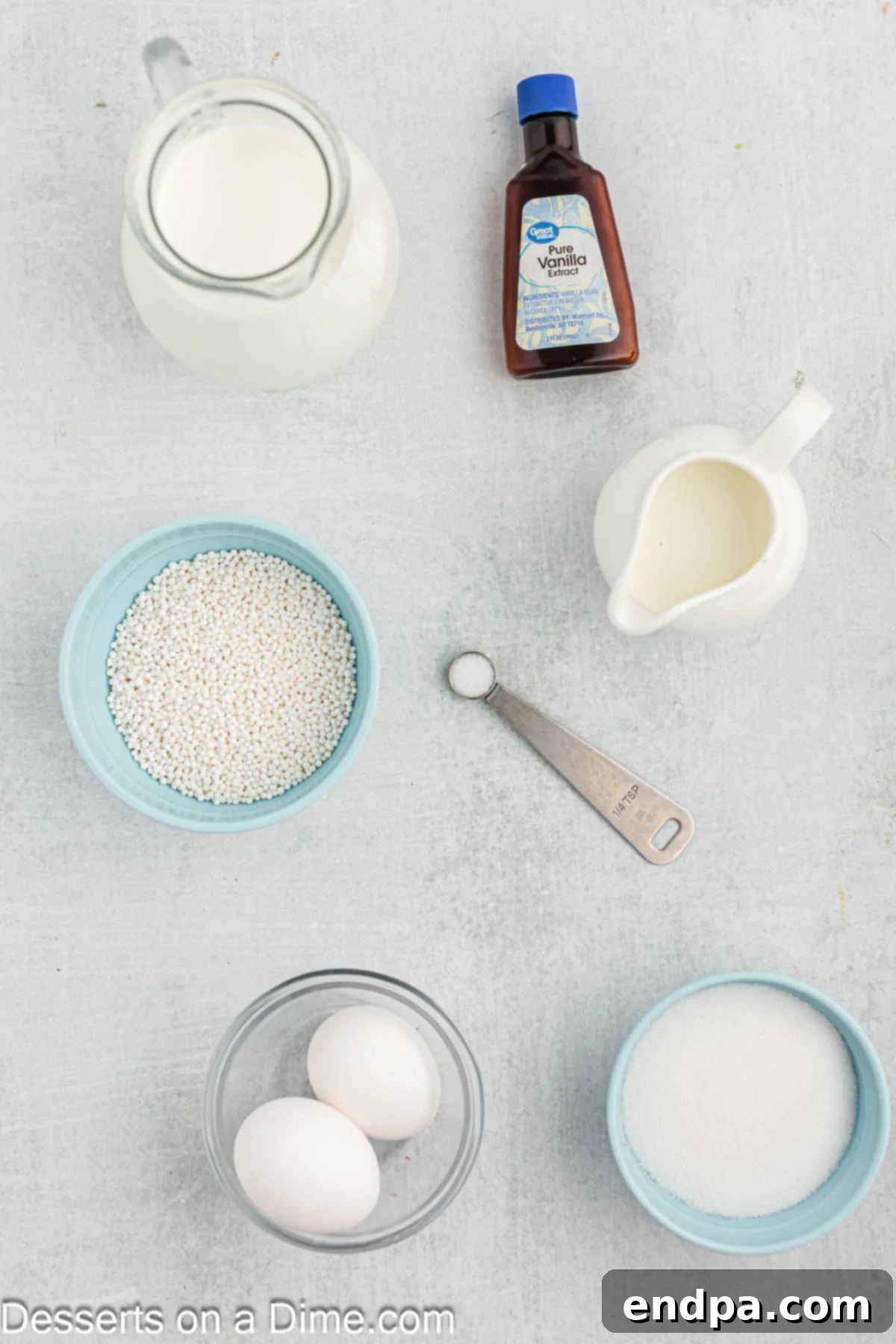 All the essential ingredients for tapioca pudding laid out: milk, half and half, vanilla extract, granulated sugar, fresh eggs, and small tapioca pearls.