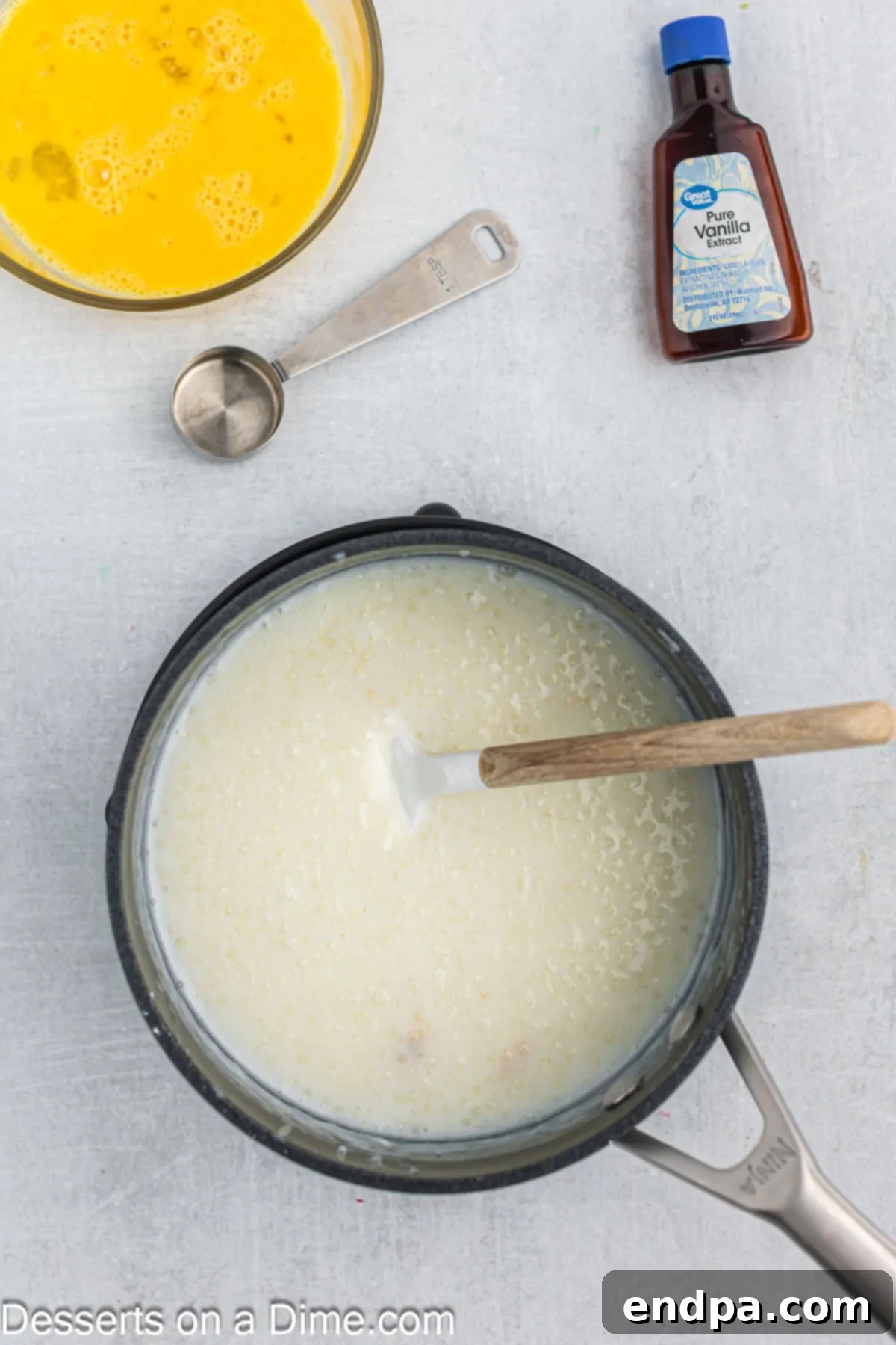 The tapioca mixture in the saucepan simmering gently with sugar incorporated, visibly thickening.