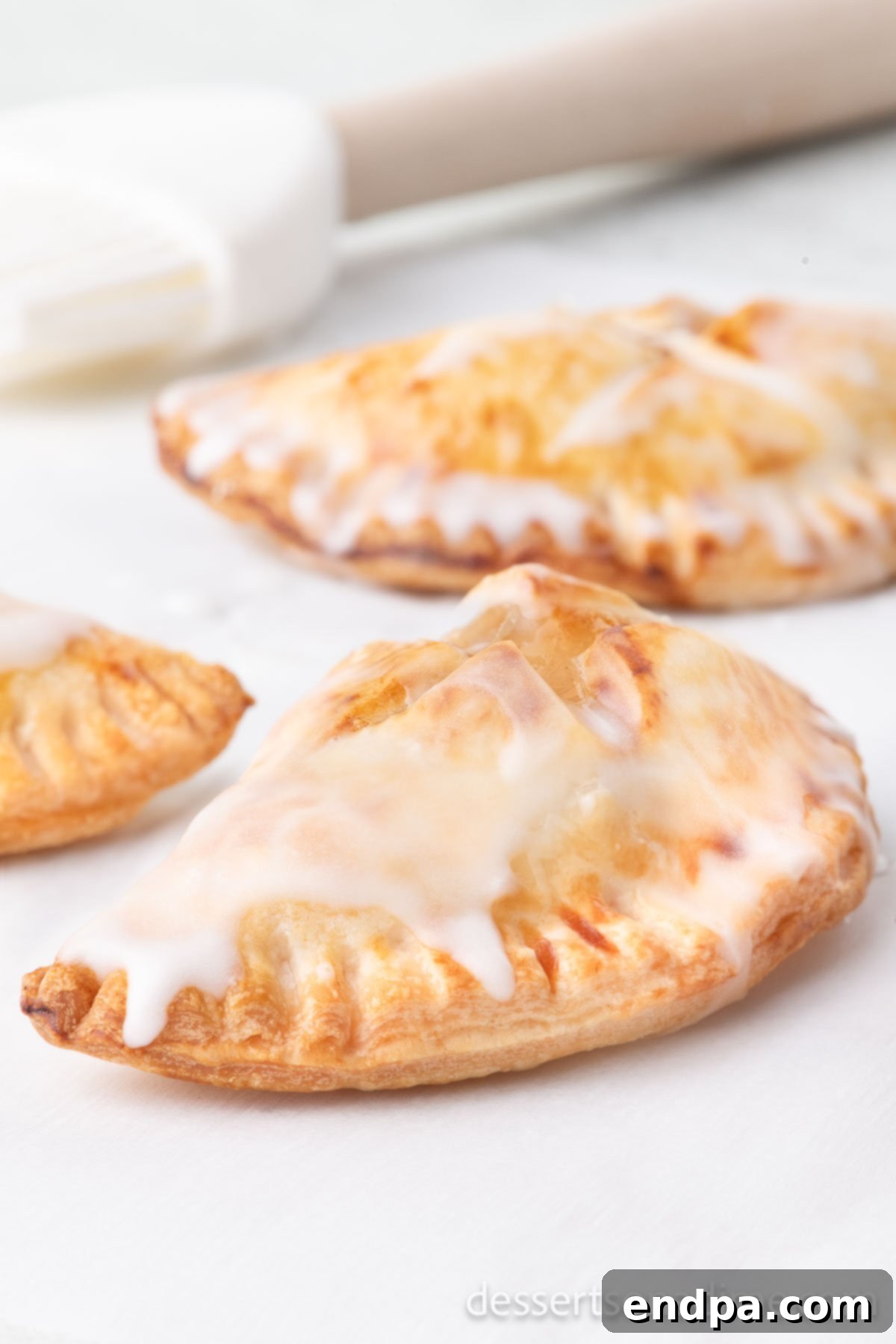 Finished air fryer hand pies, perfectly golden brown and topped with a glistening glaze, ready for serving.
