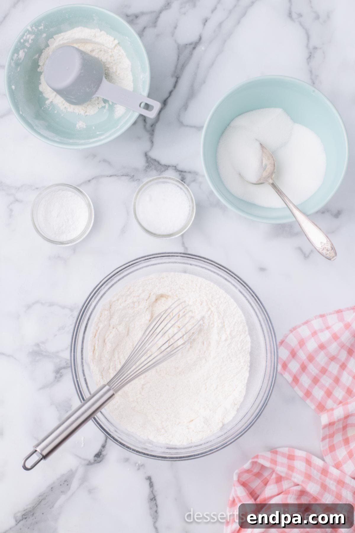 Large mixing bowl with dry ingredients: all-purpose flour, granulated sugar, baking powder, and salt, ready to be whisked together.