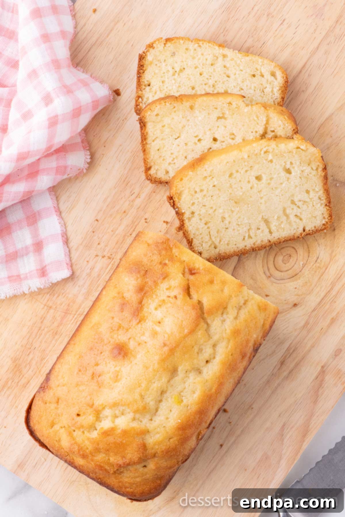 A freshly baked sweet bread loaf, expertly sliced on a wooden cutting board, ready to be savored with a spread of butter or jam.