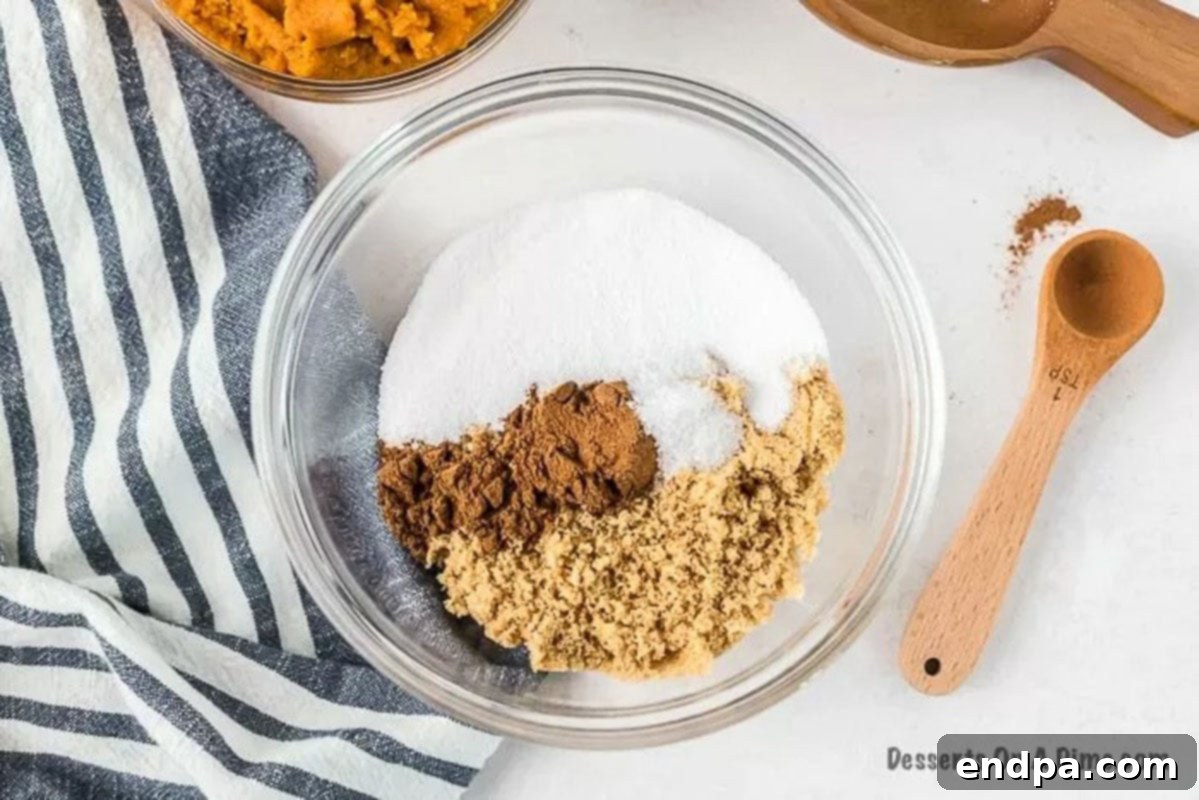 In a small bowl, various dry ingredients including brown sugar, white sugar, salt, and pumpkin pie spice are mixed together with a whisk.
