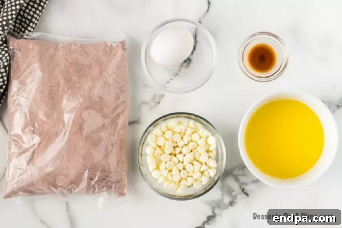 Ruby Red Brownie Bliss 3 Ingredients laid out to make red velvet brownies: red velvet cake mix, egg, butter, vanilla extract, and white chocolate chips.