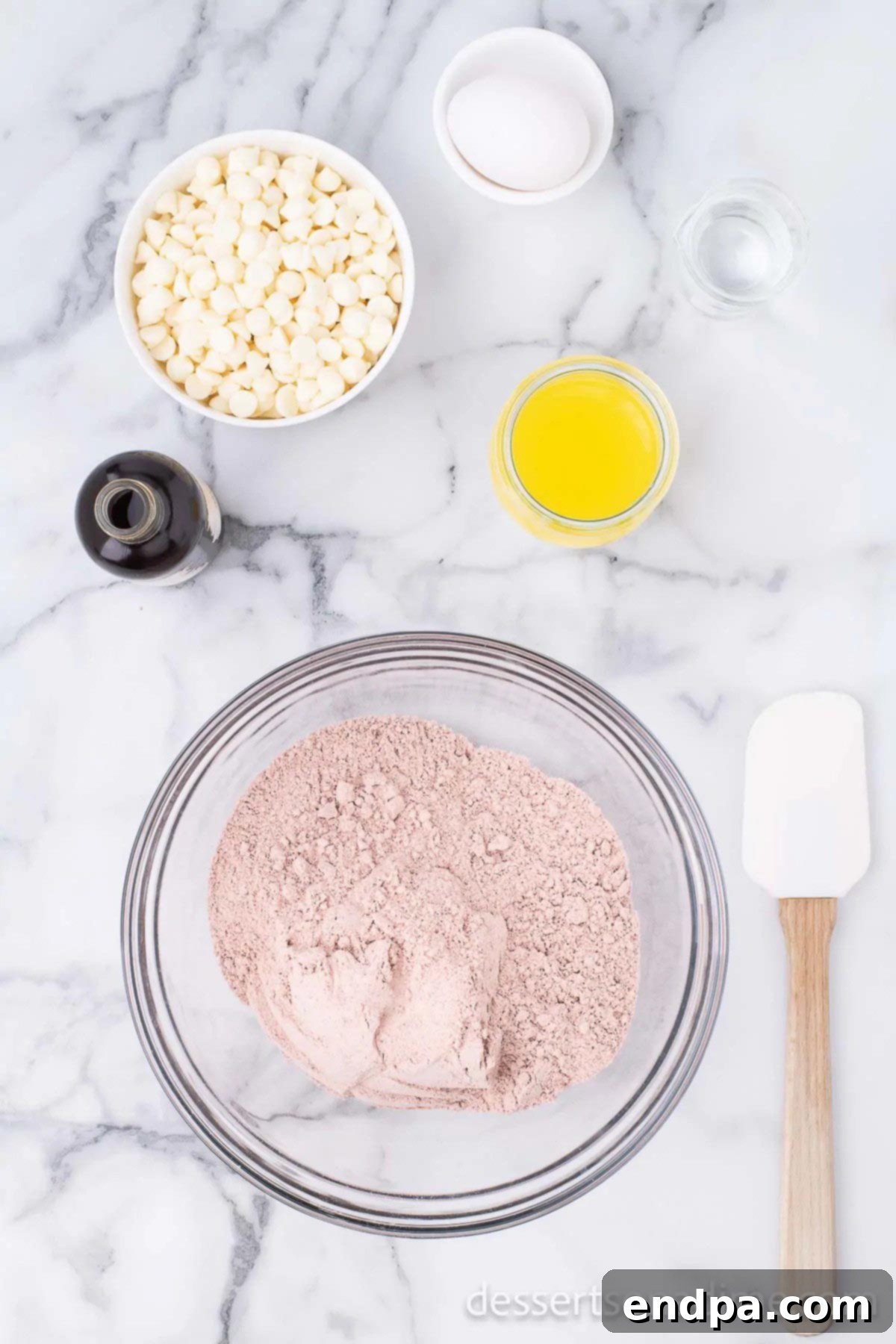 Ruby Red Brownie Bliss 4 Dry ingredients in a bowl with a bowl of white chocolate chips on the side.