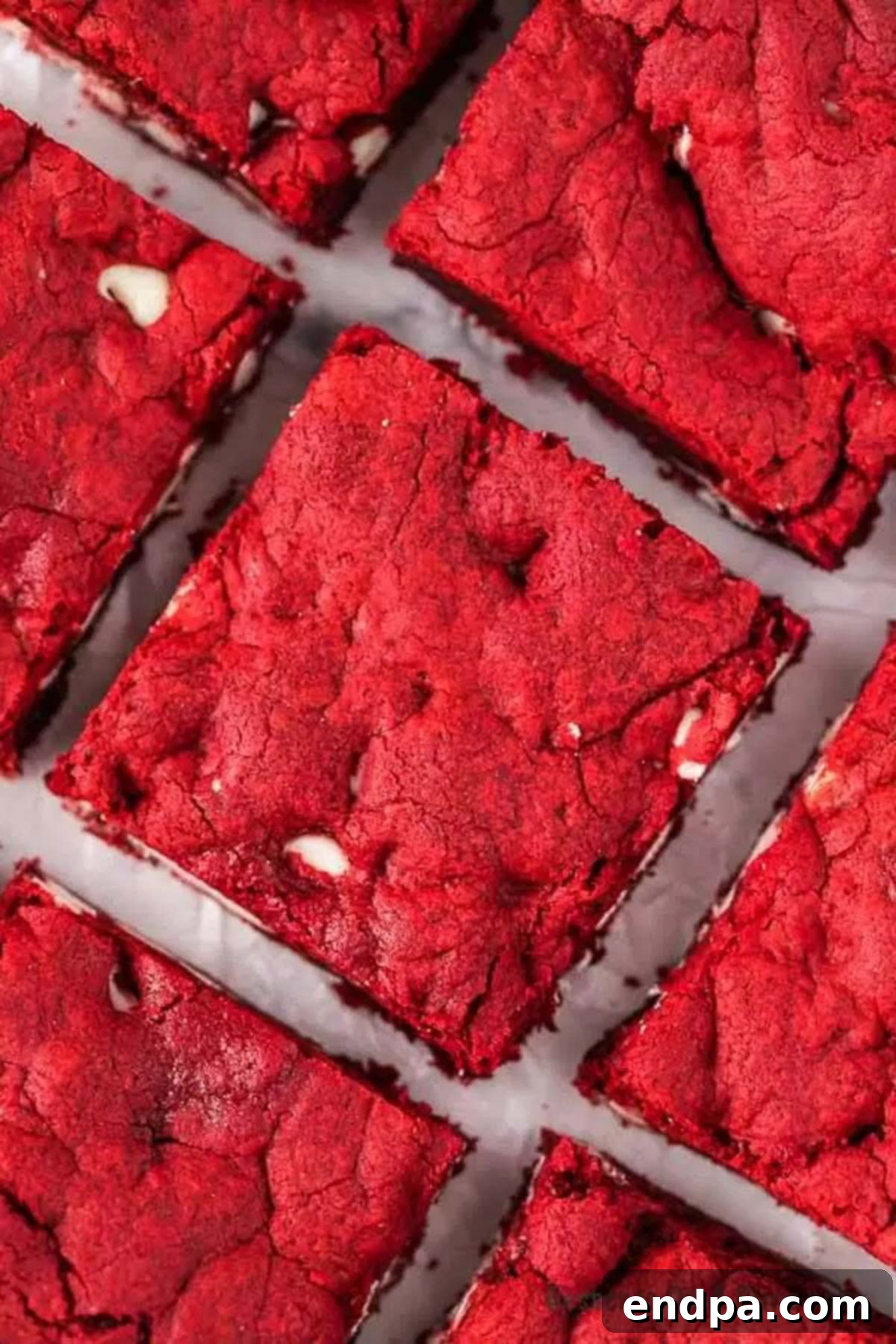 Ruby Red Brownie Bliss 8 Multiple Red Velvet Brownies laying next to each other on a sheet of wax paper, showing their soft centers.