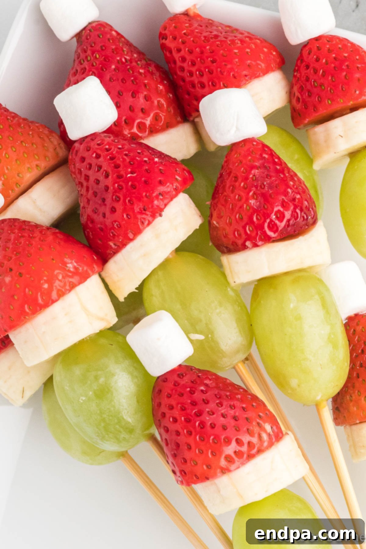 Grinch Fruit skewers beautifully arranged on a platter, ready to be served at a holiday party.