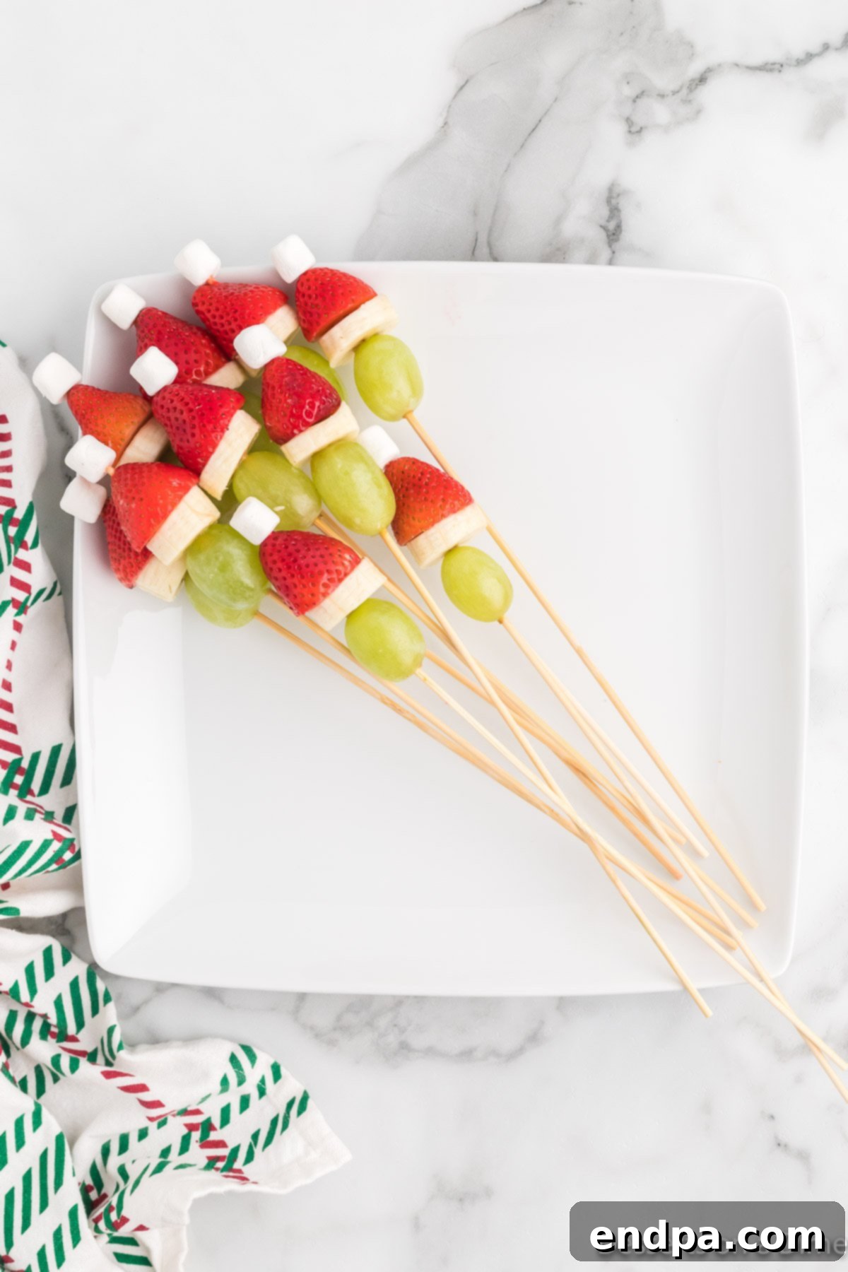 Assembled Grinch fruit skewers presented beautifully on a serving platter, ready for guests to enjoy.