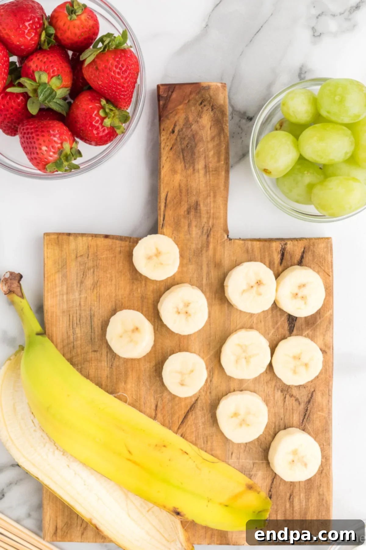 A peeled banana sliced into thick, uniform portions, ensuring stability on the skewers.