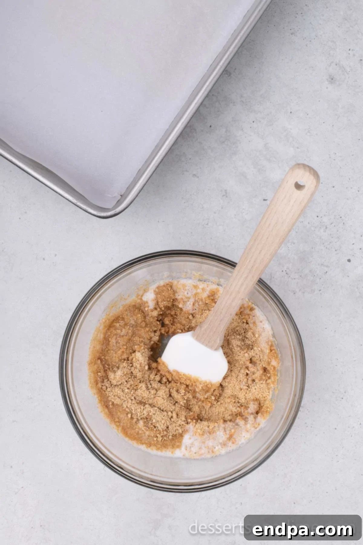 Irresistible Magic Cookie Bars Recipe 3 Graham cracker crumbs mixed with butter in a bowl.