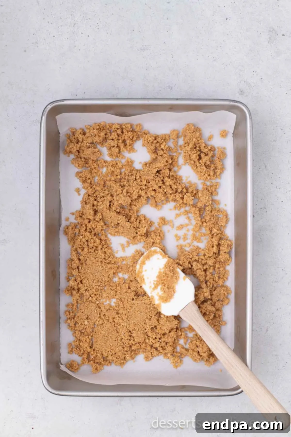 Irresistible Magic Cookie Bars Recipe 4 Graham cracker crumbs spread evenly into a baking dish.