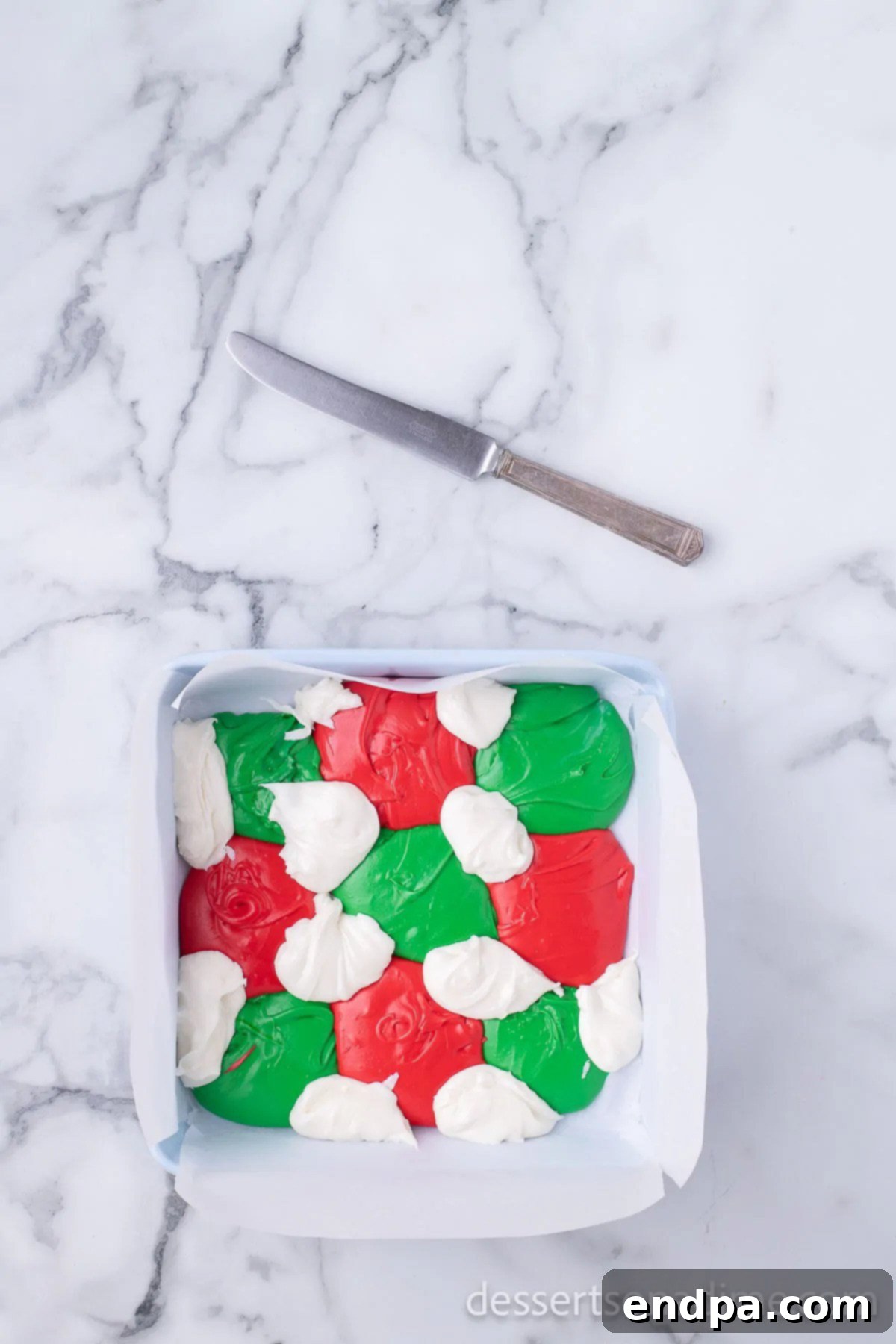 All colored fudge mixtures distributed evenly across the pan, ready for swirling.