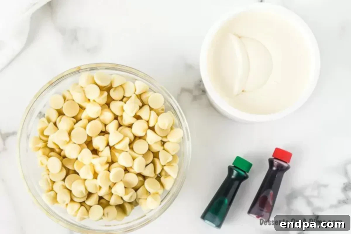 White chocolate chips, vanilla frosting, and red and green food coloring laid out as ingredients for Christmas fudge.