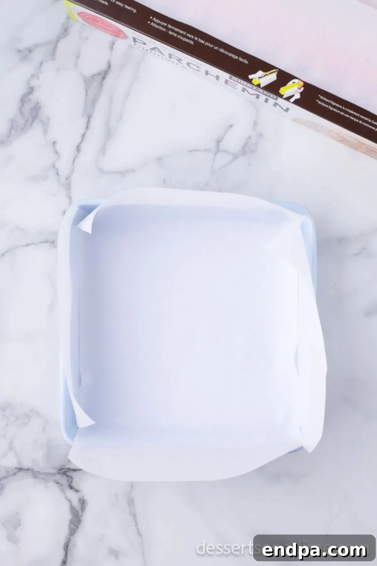 Baking dish meticulously lined with parchment paper, ready for fudge mixture.