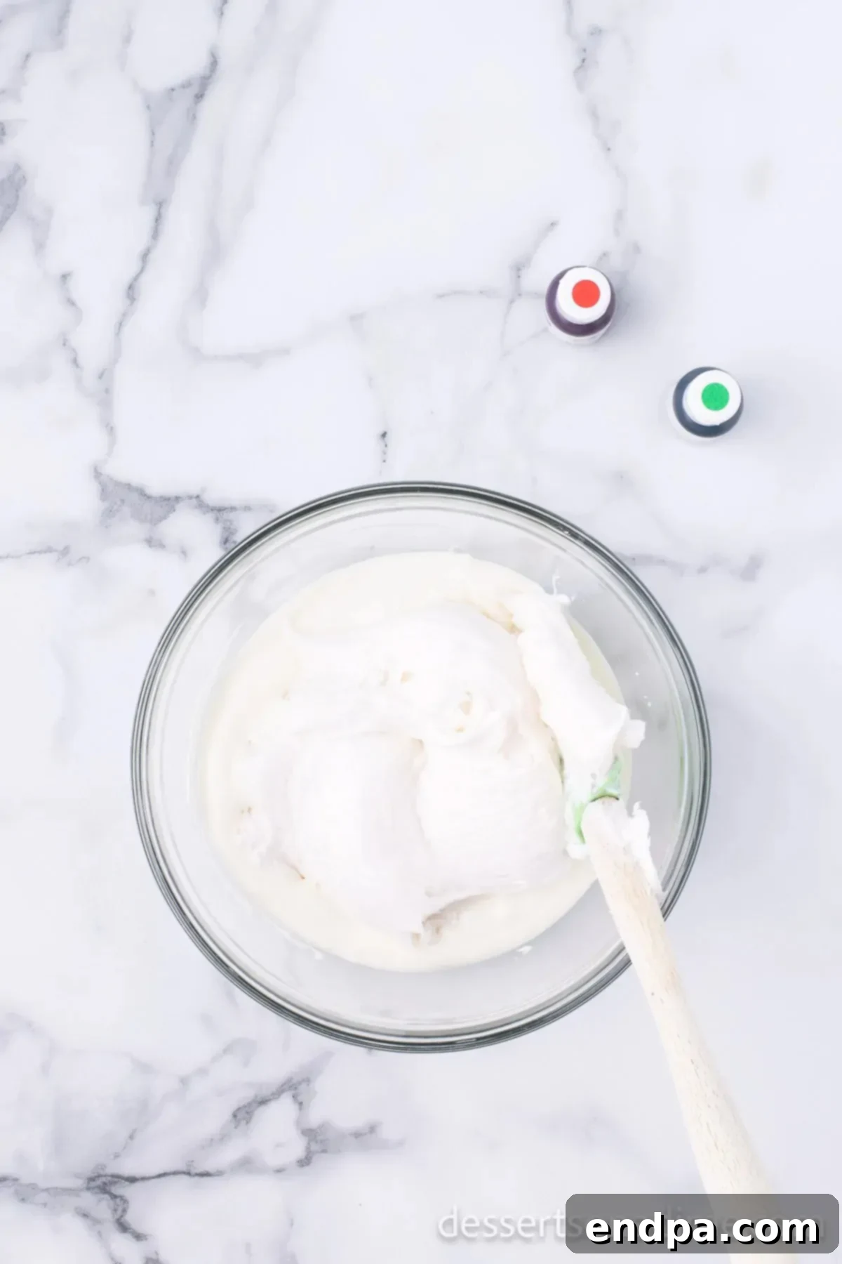 Melted white chocolate being stirred in a bowl, showcasing its smooth consistency.