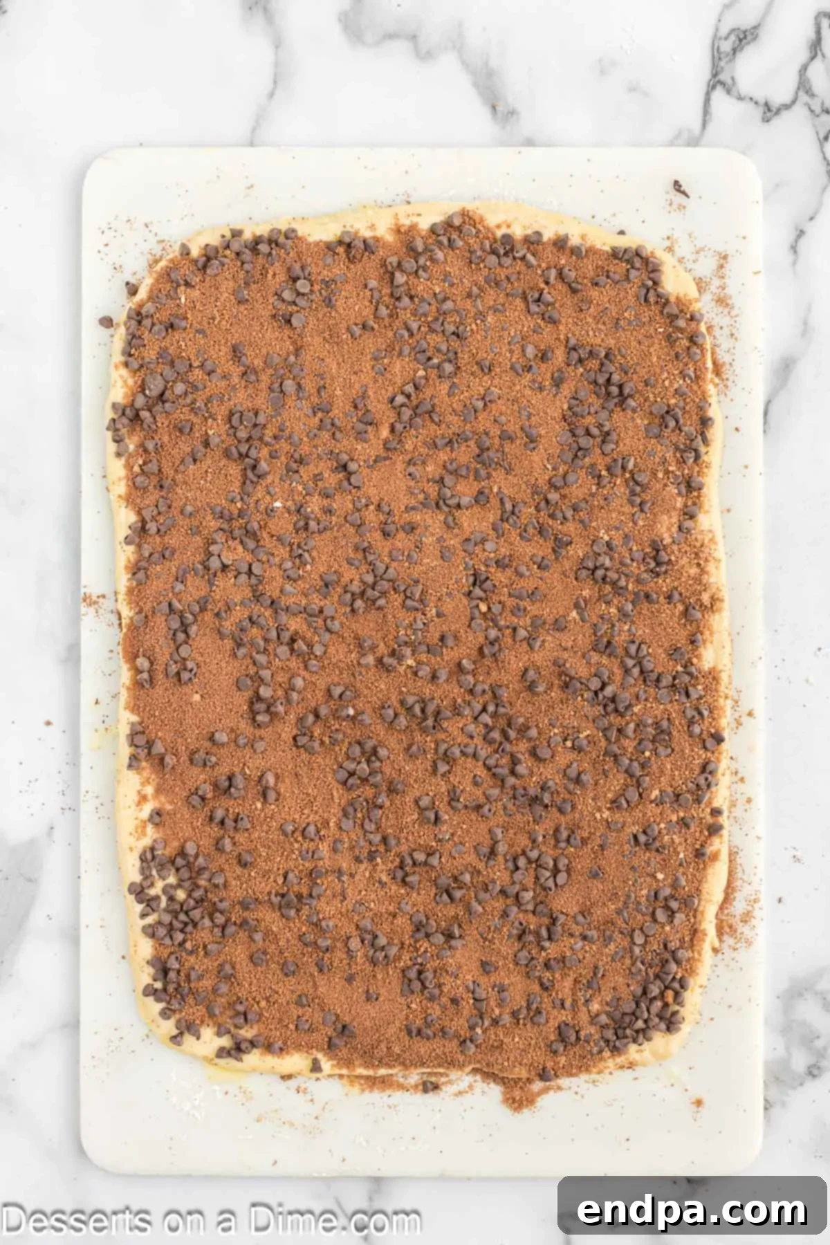 The chocolate cinnamon mixture spread evenly over the buttered dough, with remaining butter drizzled on top.