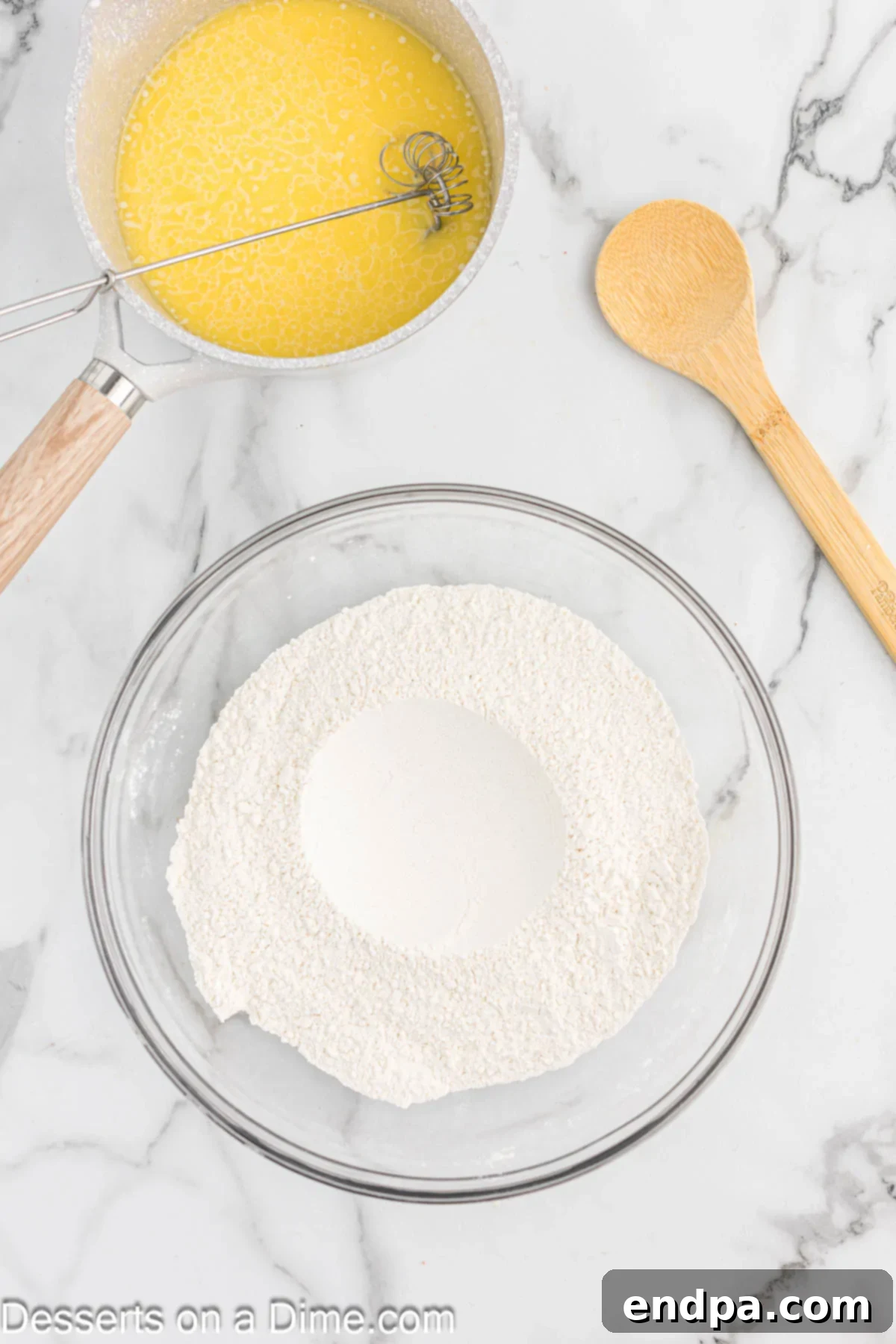 Flour, sugar, and salt combined in a large mixing bowl, with a well created in the center.