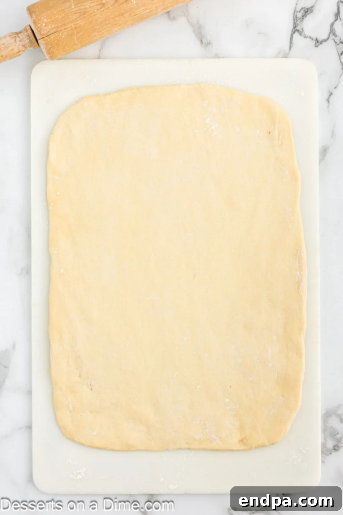 Dough punched down and rolled out into a large rectangle on a floured surface.