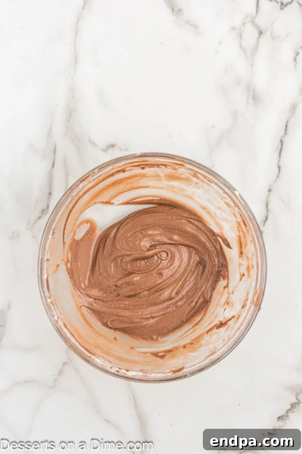 A bowl containing the combined chocolate cinnamon filling mixture: cocoa powder, brown sugar, mini chocolate chips, and cinnamon.