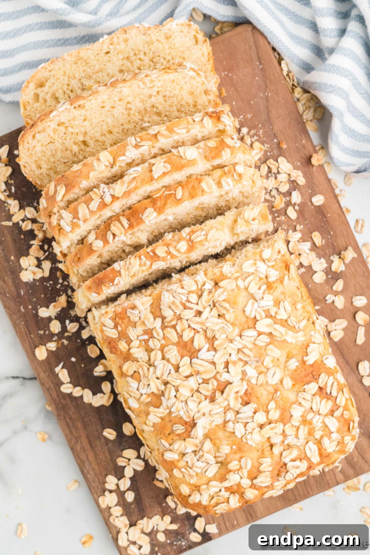 A perfectly baked loaf of homemade oatmeal bread, sliced and presented beautifully.