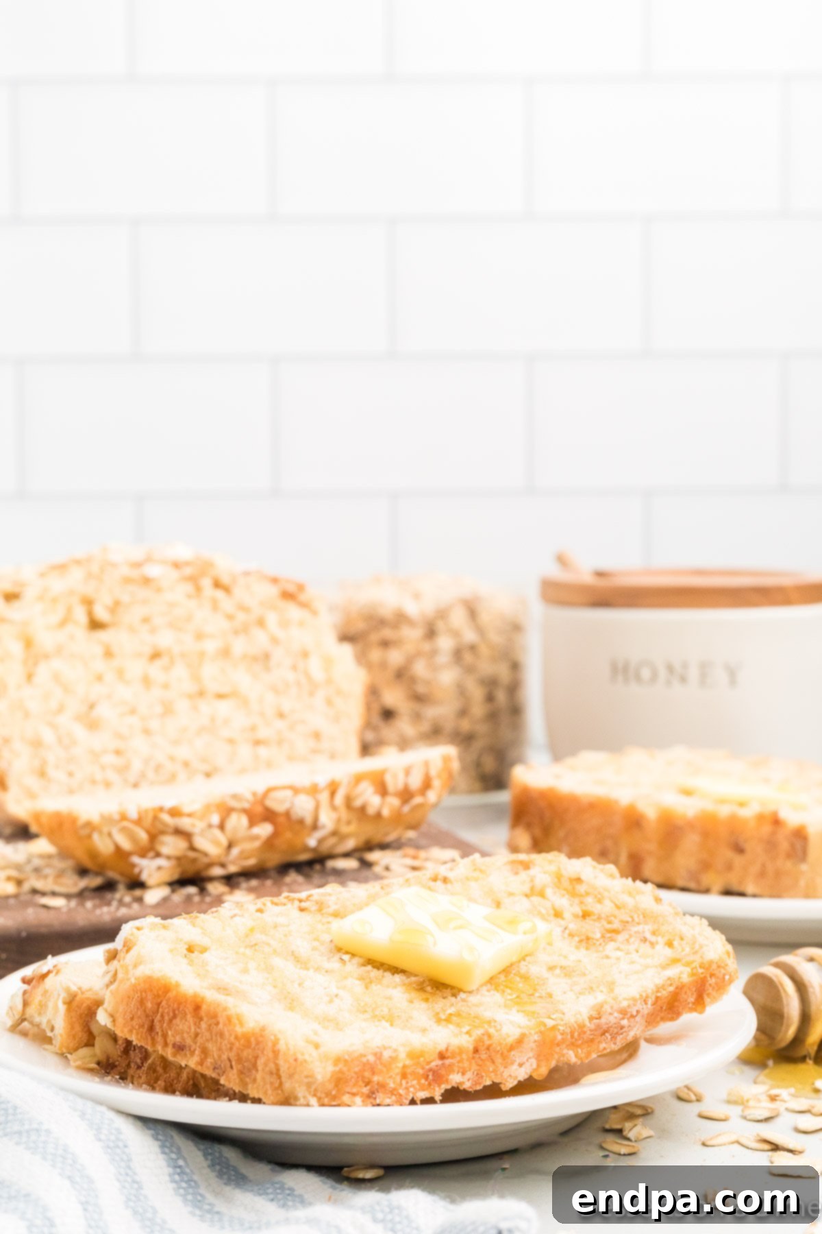 A close-up of oatmeal bread dough being kneaded on a floured surface.