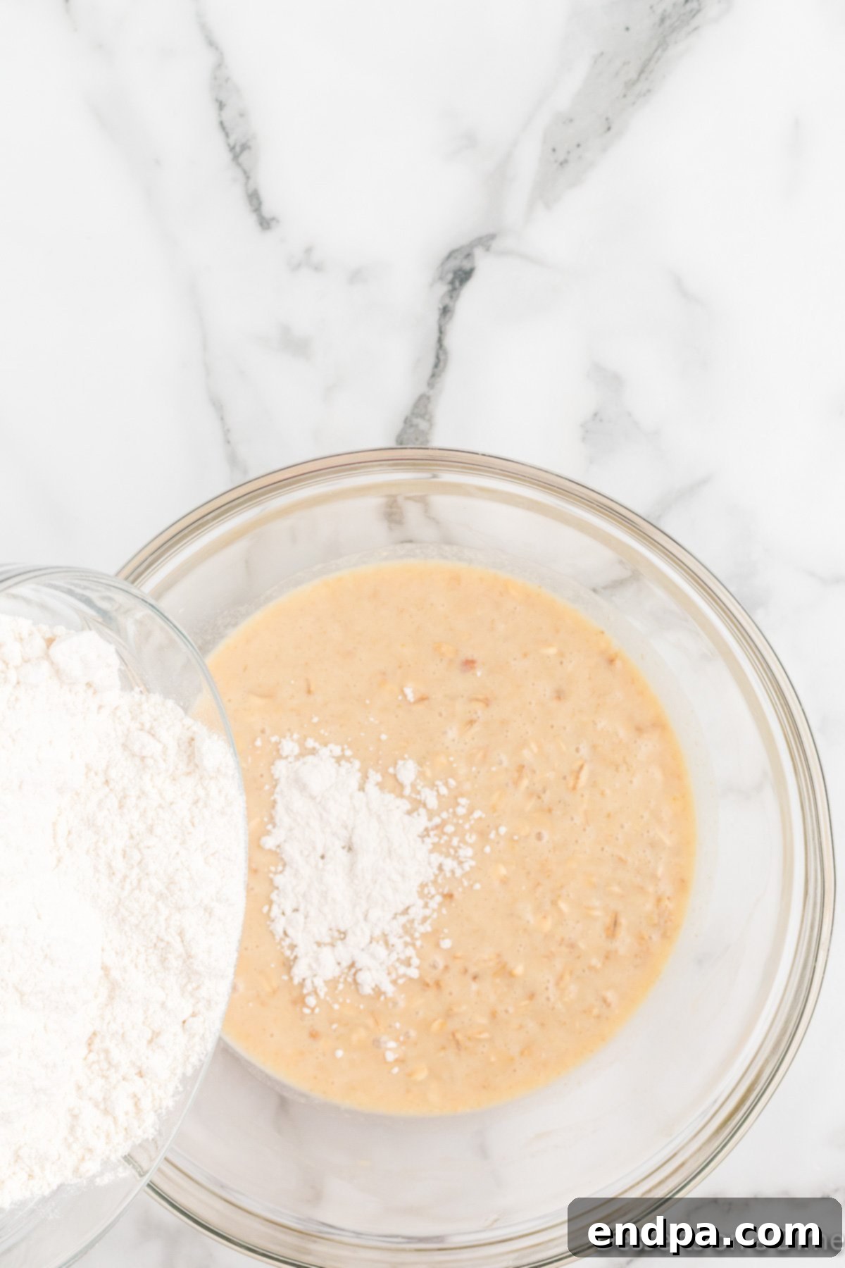 Mixing honey, salt, oatmeal mixture, and egg with yeast.