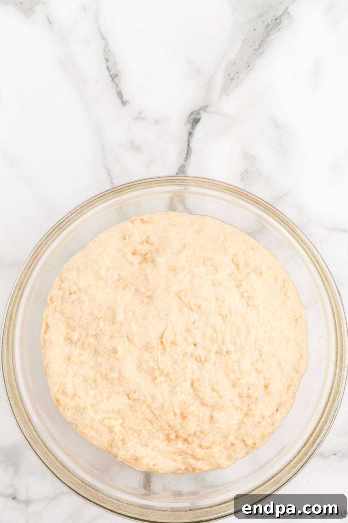Bread dough covered with plastic wrap during its first rise.