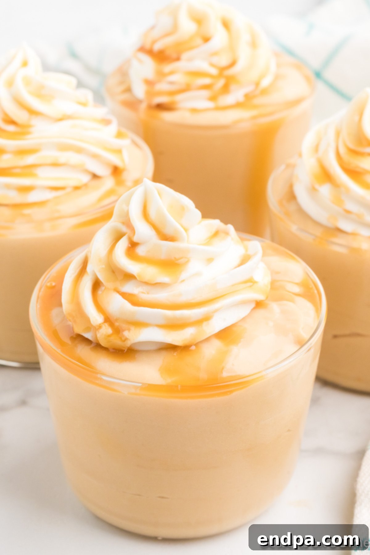 Pudding in cups topped with whipped cream.