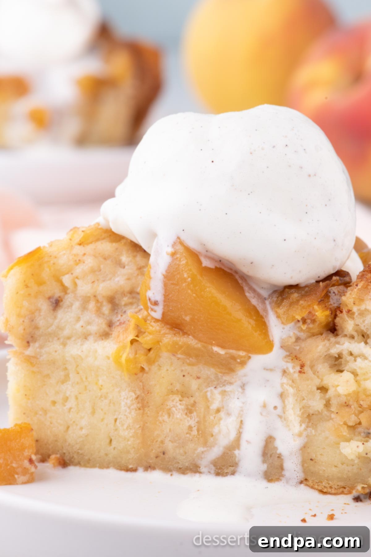 Summer Peach Bread Delight 4 Close-up of baked peach bread pudding garnished with fresh mint, a dusting of powdered sugar, and a scoop of melting vanilla ice cream.
