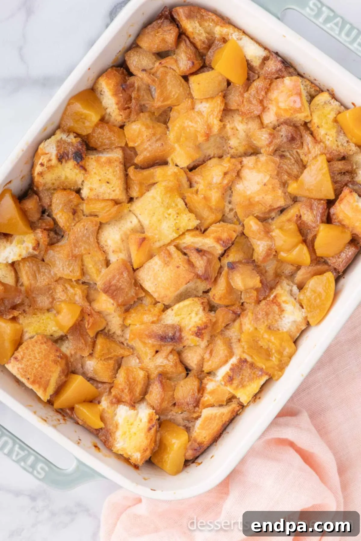 Summer Peach Bread Delight 9 Baked peach bread pudding, golden brown and perfectly set, cooling in a casserole dish.