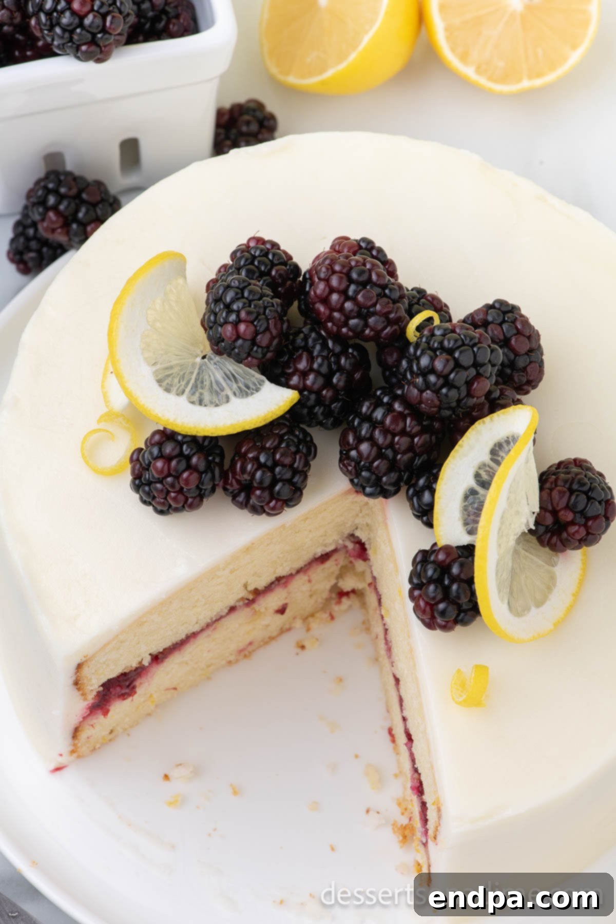 Luscious Lemon Blackberry Cake 16 A close-up of a slice of Lemon Blackberry Cake, beautifully layered and garnished, ready to be enjoyed.