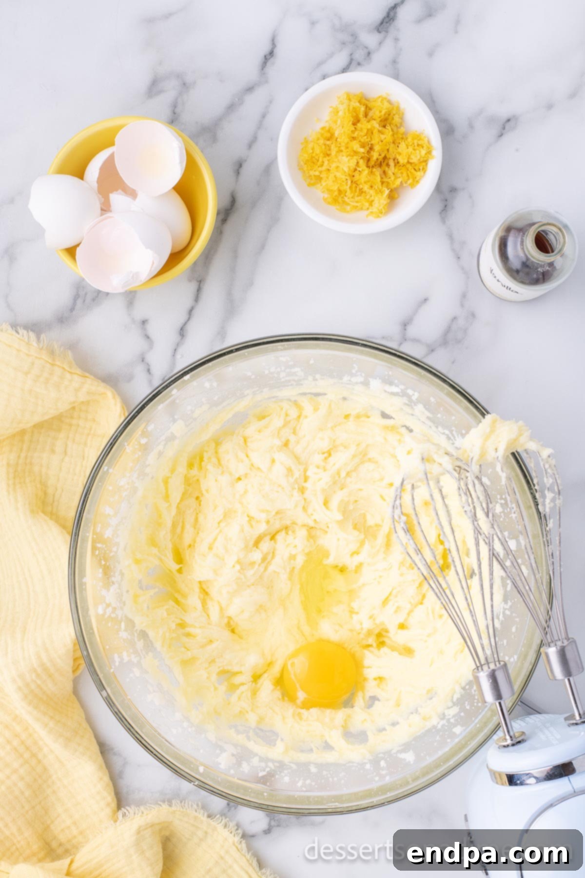 Luscious Lemon Blackberry Cake 5 A mixing bowl with eggs being incorporated into the creamed butter and sugar mixture.
