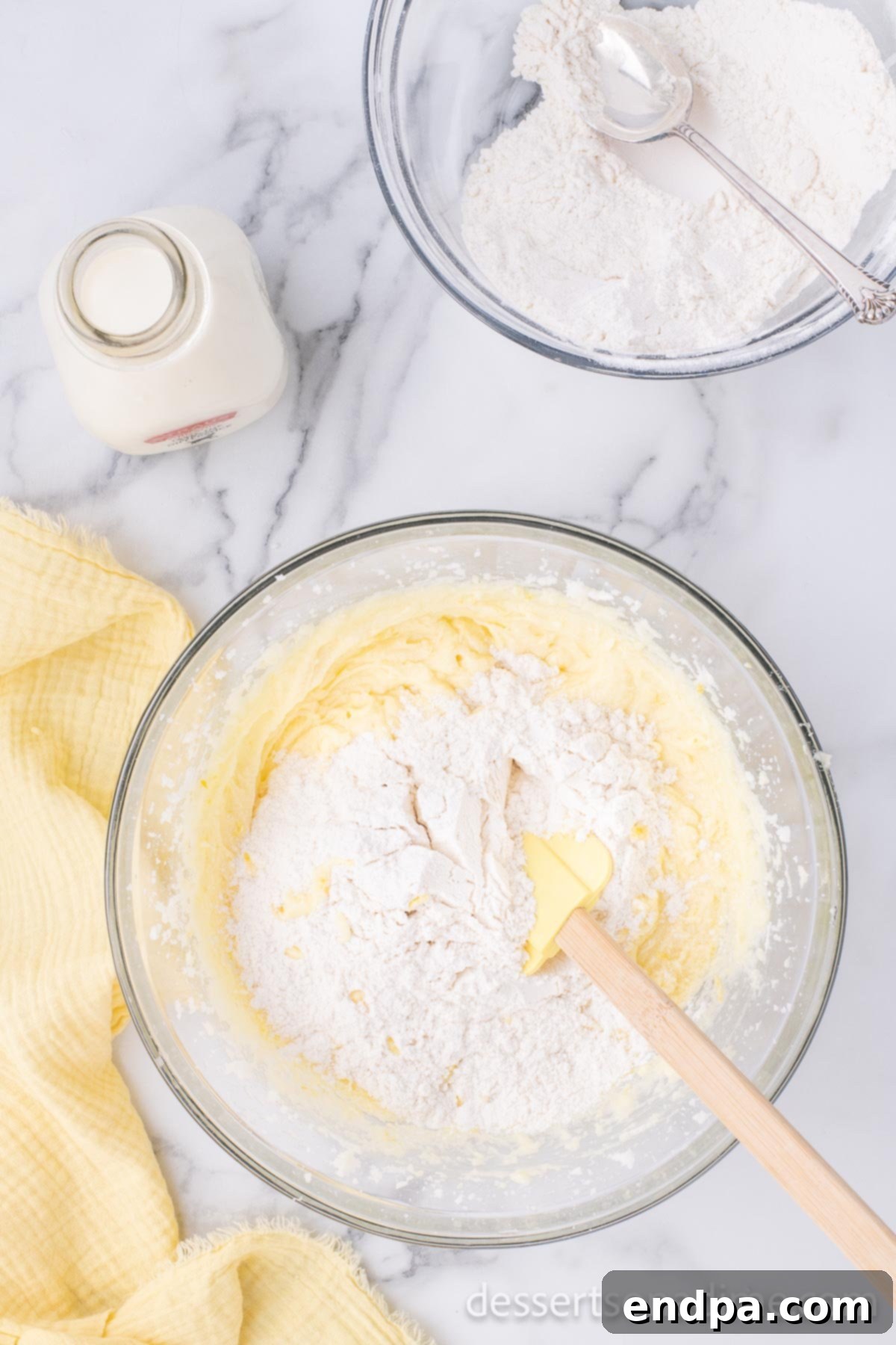 Luscious Lemon Blackberry Cake 6 Dry flour mixture being incrementally added to the wet batter in a mixing bowl.