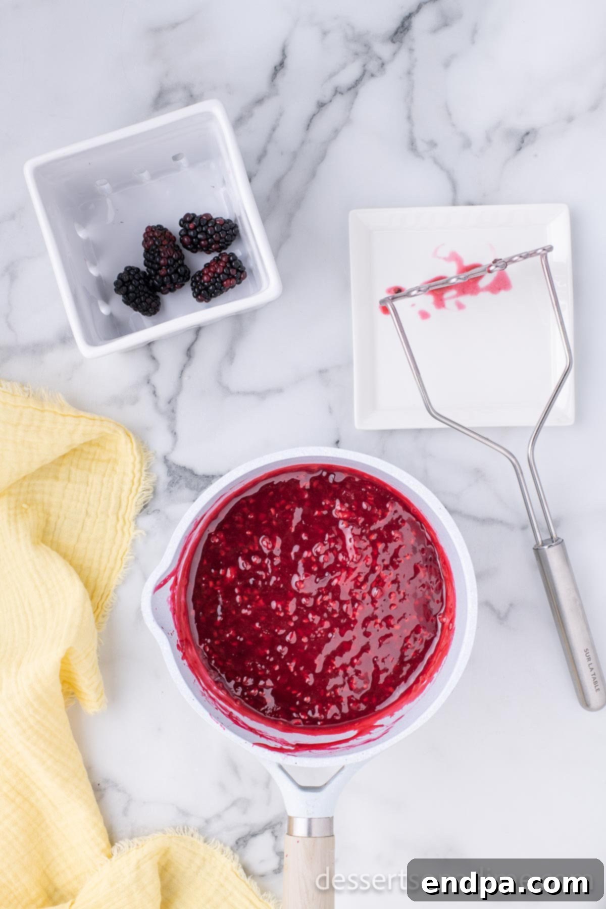 Luscious Lemon Blackberry Cake 9 Blackberry filling simmering and thickening in a saucepan on the stovetop.