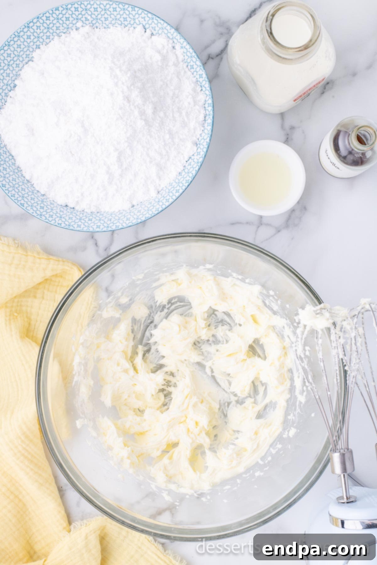 Luscious Lemon Blackberry Cake 10 A mixing bowl with butter and powdered sugar being beaten together to make frosting.