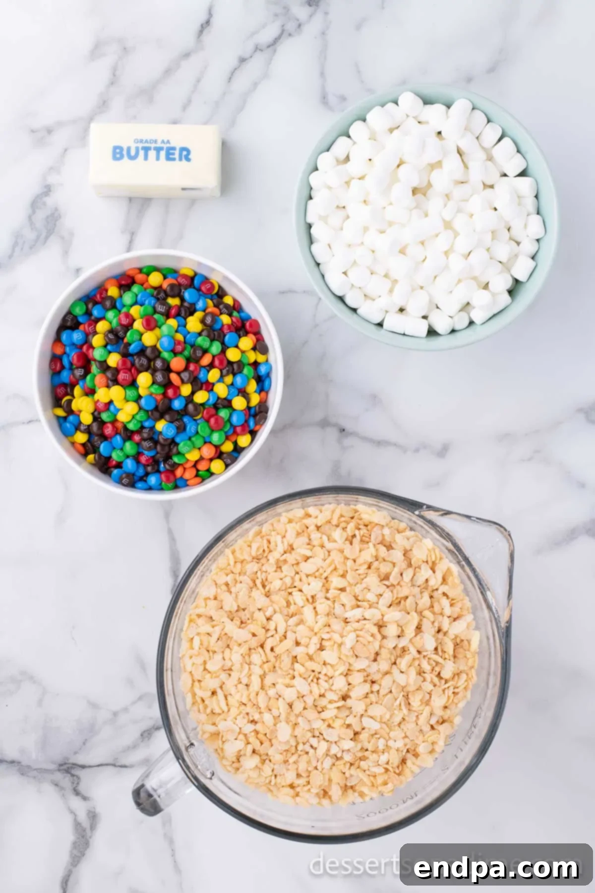 Ingredients for rice krispy treats - rice cereal, salted butter, marshmallows and mini M&Ms. 