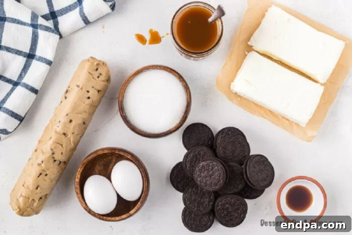 Ultimate Decadence Cheesecake Bars 3 Key ingredients laid out: chocolate chip cookie dough, Oreos, cream cheese, sugar, eggs, vanilla extract, and caramel sauce