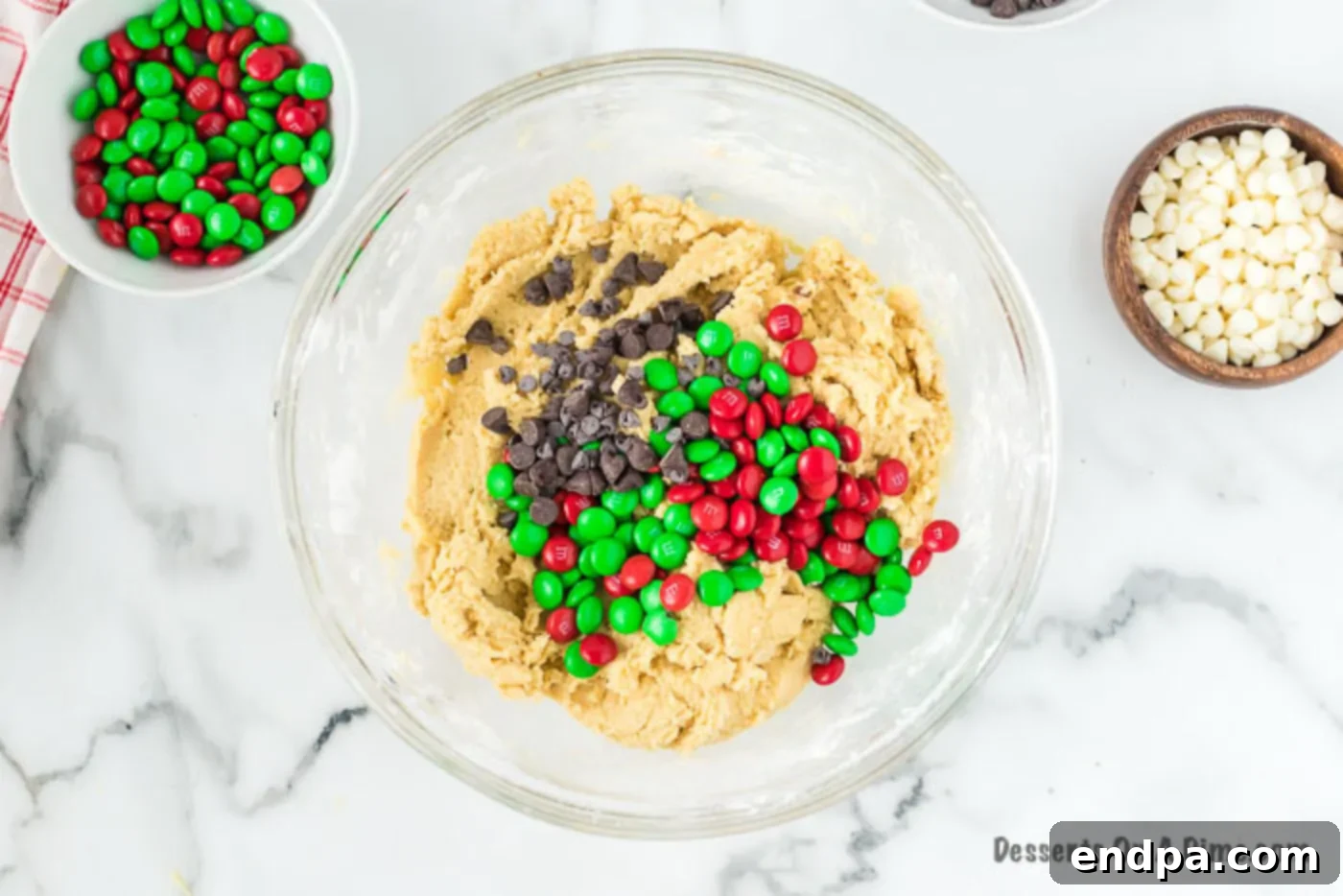 Joyful Christmas Cookie Bars 3 Half of the Christmas M&M's and chocolate chips being folded into the cookie dough mixture.