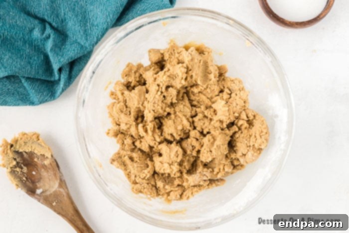 Shortening and brown sugar being creamed together in a mixing bowl.