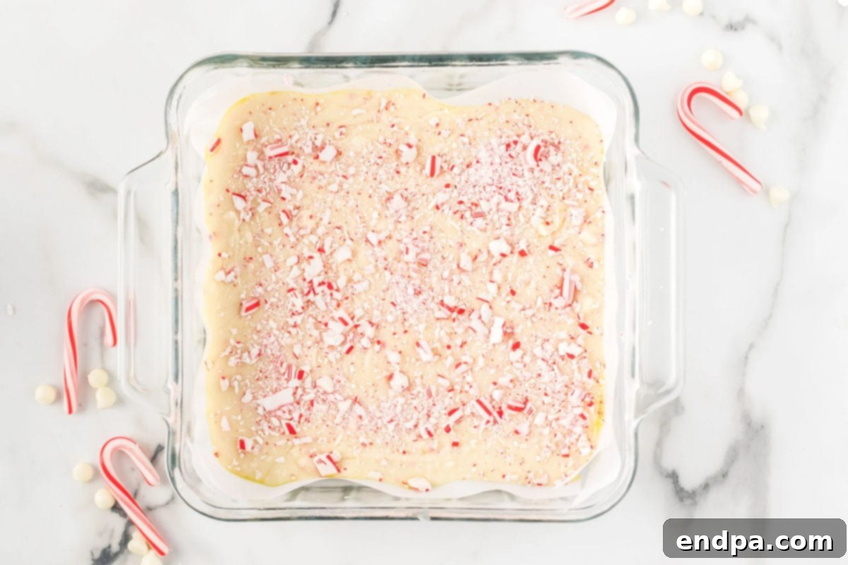 Peppermint fudge mixture poured into a baking dish lined with parchment paper.