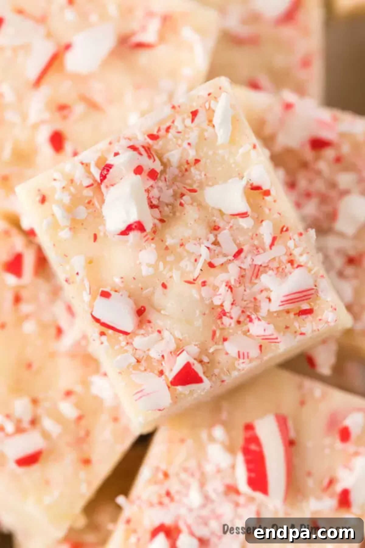 Close-up of neatly cut peppermint fudge squares, stacked on a plate.