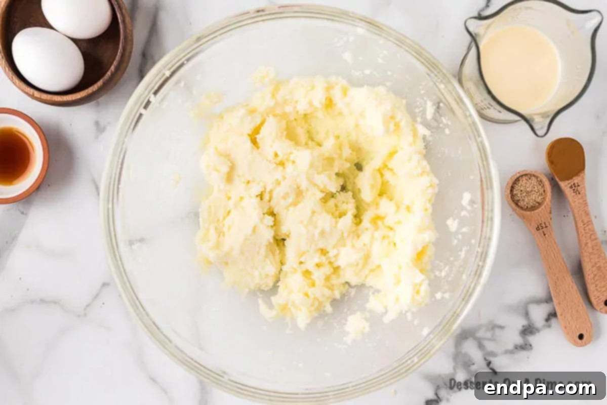 Butter and sugar being creamed together in a mixing bowl.