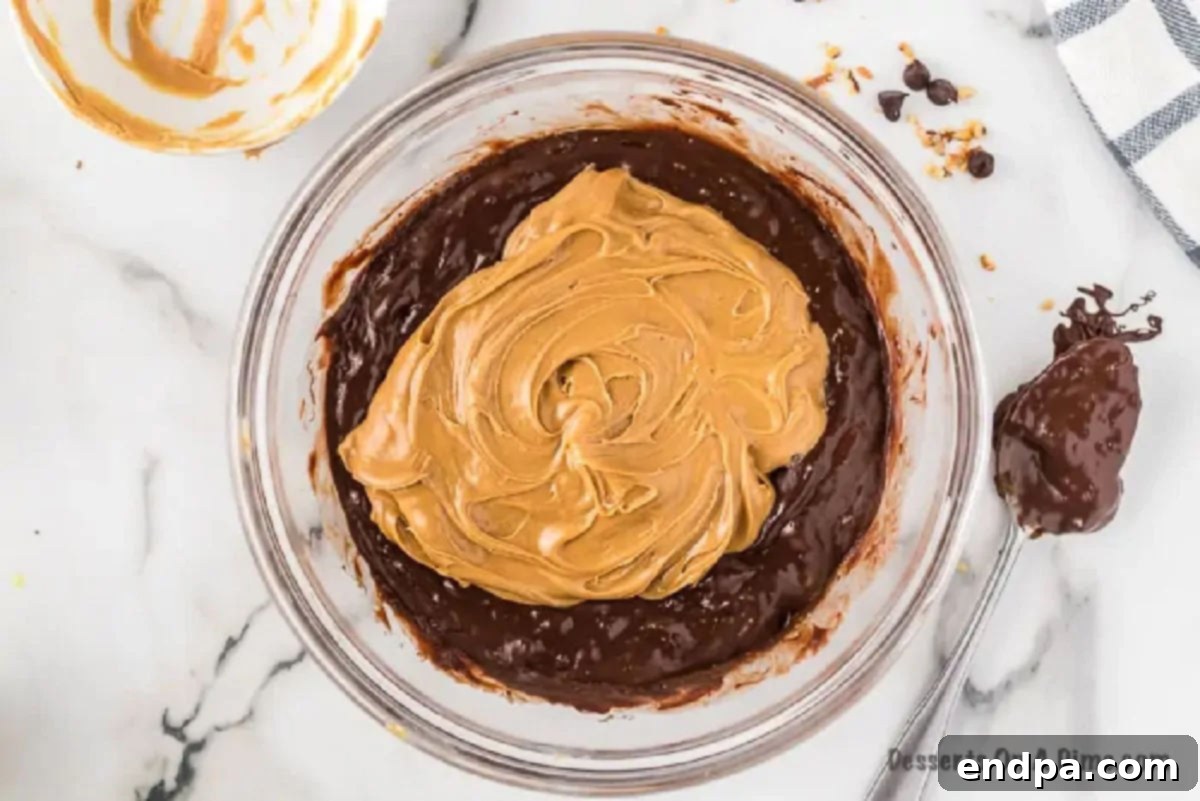 Melted chocolate and creamy peanut butter being stirred together in a mixing bowl, creating a rich, glossy fudge base.