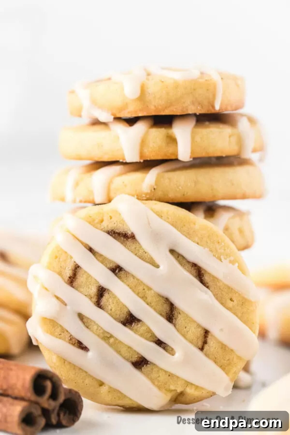 Cinnamon Roll Cookies stacked together, showcasing the beautiful cinnamon swirls and icing.